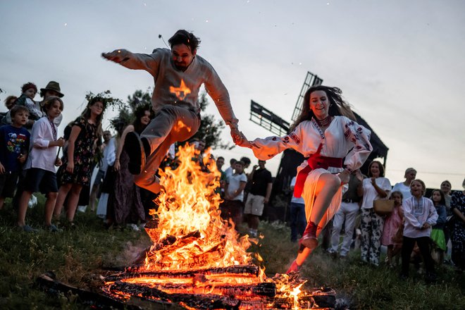 Ljudje skačejo čez ogenj v ukrajinski vasi Vytachiv med praznovanjem tradicionalnega praznika Ivana Kupala, starodavne tradicije, ki izvira iz poganskih časov in je zaznamovana z velikim nočnim praznovanjem, med katerim ljudje pojejo in plešejo ob ognju, saj verjamejo, da jih bo to očistilo grehov in jih naredilo bolj zdrave. Foto: Viacheslav Ratynskyi/Reuters