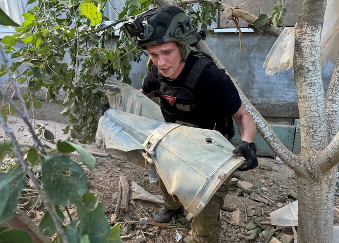 Pripadnik oddelka, ki s terena v Harkovu odnaša neeksplodirana ubojna sredstva. FOTO: Vitalii Hnidyi/Reuters