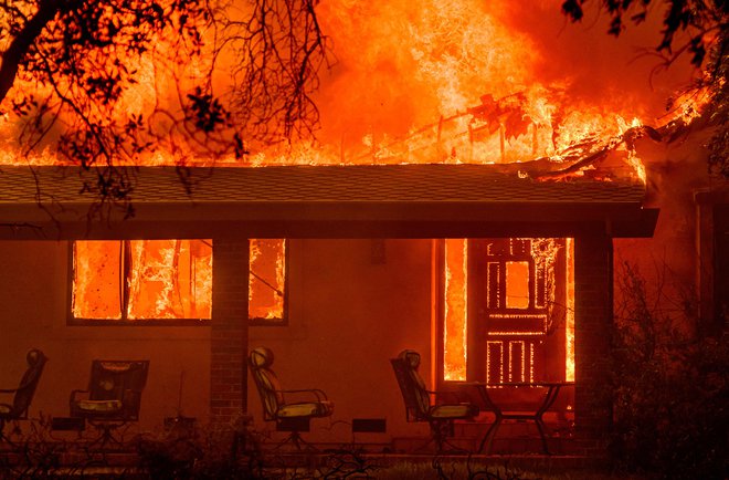 Med požarom Thompson v mestu Oroville v Kaliforniji so plameni zajaeli hišo. Zaradi vročinskega vala temperature naraščajo, zato so po vsej amriški zvezni državi izdana opozorila o požarih. Foto Josh Edelson Afp