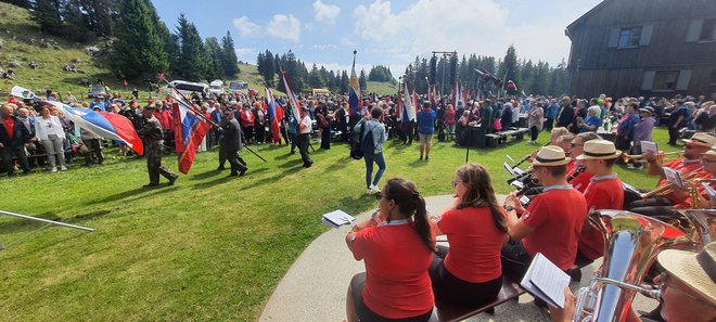 Pri planinskem domu na Menini planini so plapolali številni prapori domoljubnih društev. FOTO: Bojan Rajšek/Delo