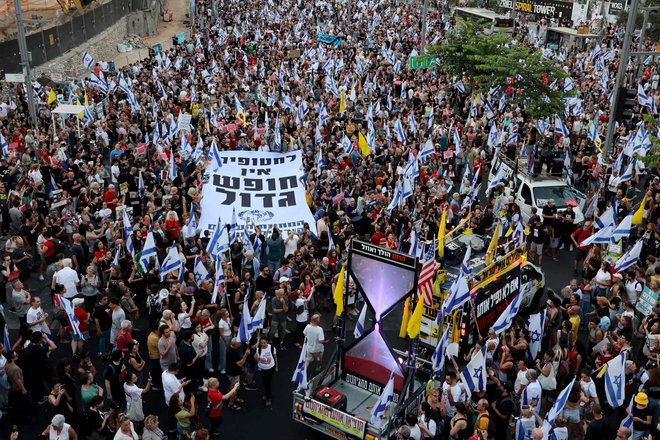 Protestniki nosijo izraelsko zastavo in transparent z napisom Za talce ni velike svobode. FOTO: Gil Cohen-Magen/AFP