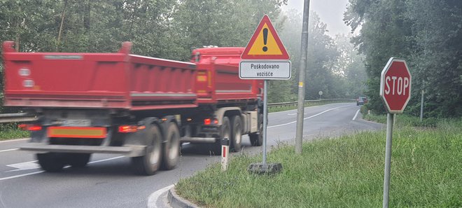 Namesto da bi cesto redno vzdrževali, so raje postavili prometni znak za nevarnost. FOTO: Bojan Rajšek/Delo