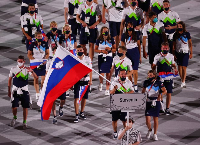 V Tokiu sta zastavo Slovenije nosila Eva Terčelj in Bojan Tokić. Foto Mike Blake/Reuters