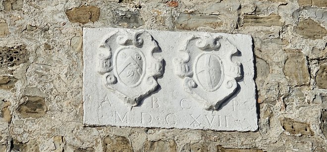 V piranskem obrambnem stolpu je vgrajena bela kamnita plošča z dvema grboma: podestata Bemba in grb mesta Piran ter letnica 1617, ko so izpeljali eno od prenov utrdbe. Foto Boris Šuligoj