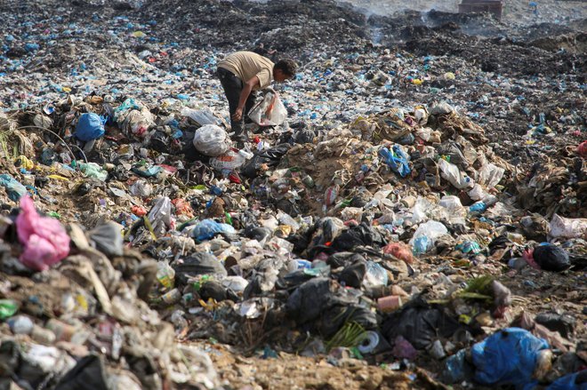 Palestinec na smetišču brska za uporabnimi predmeti FOTO: Hatem Khaled/Reuters