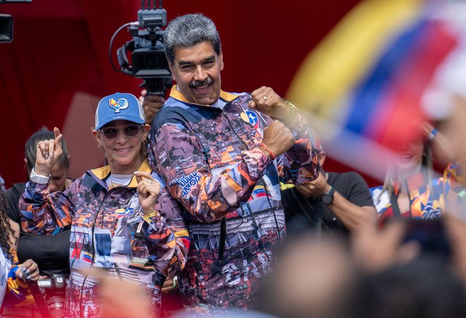 Nicolás Maduro (na fotografiji z ženo Cilio Flores) pravi, da bo deželo zajela bratomorna vojna, če mu bo kdo preprečil zmago. FOTO: Juan Barreto/AFP
