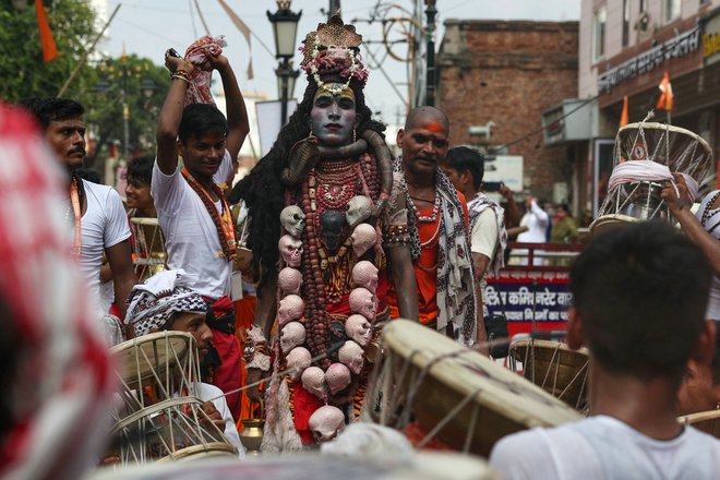 Hindujski vernik je oblečen v boga Šivo med procesijo ob praznovanju indijskega festivala, posvečenega hindujskemu bogu Šivi, ki zaznamuje prvi ponedeljek monsunskega meseca (Sawan), v Varanasiju. Foto: Niharika Kulkarni/Afp