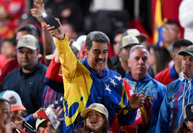 Opozicija trdi, da je pri štetju glasov prišlo do številnih nepravilnosti. Maduro na fotografiji s svojimi privrženci.  FOTO:  Juan Barreto/Afp