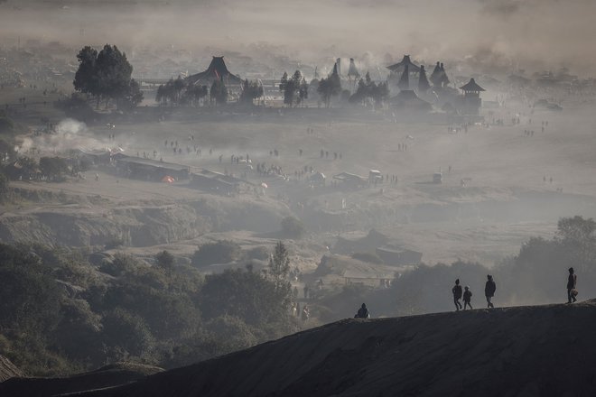 Na tisoče ljudi se je odpravilo na vrh gore Bromo (2.329 m) in svoj obred zaključilo z metanjem daritev v krater vulkana na vzhodu Jave, da bi izrazili predanost in hvaležnost prednikom in bogovom. »Da bi se odzvali na to, kar je Vsemogočni sporočil prek narave, se morajo ljudje prilagoditi in ne smejo pozabiti moliti,« je dejal Suyitno, tenggerski duhovni vodja. Foto: Willy Kurniawan/Reuters