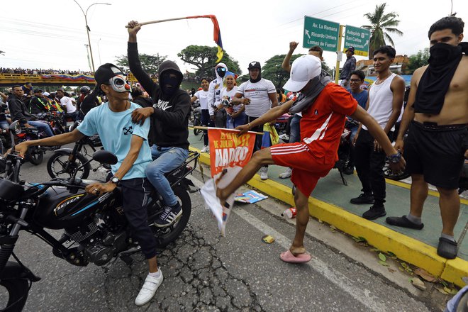 Brcanje in sežiganje volilnih plakatov Nicolasa Madura je bil glavni del protestniške folklore.  FOTO:Juan Carlos Hernandez/AFP