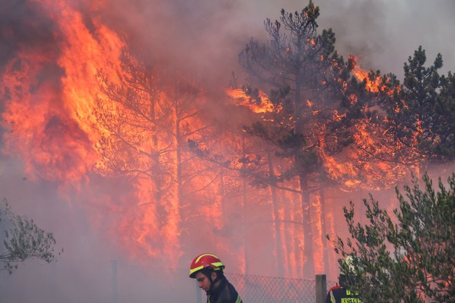 Po informacijah s terena, na katere se sklicuje lokalni portal Šibenski.hr, je ogenj že dosegel območje dveh bližnjih naselij Bratiškovci in Plastovo. FOTO: Antonio Bronic/Reuters