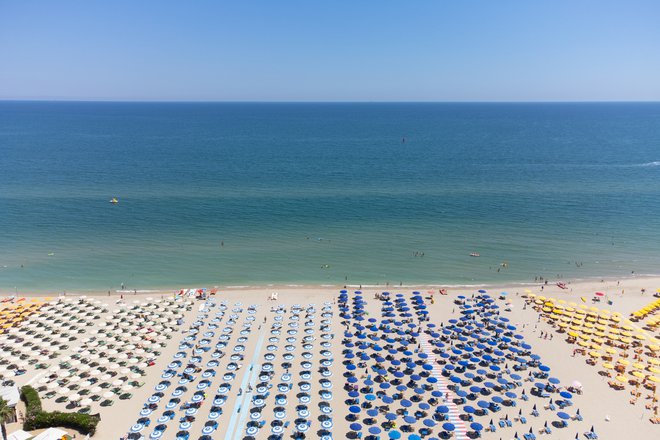 Desetletja je že stara italijanska tradicija ležalnikov in senčnikov, cele rodbine ob obali živijo od tega. FOTO: Lorenzo Di Cola via Reuters Conn