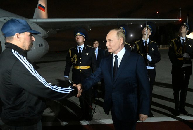Vladimir Putin na letališču pozdravlja Vadima Krasikova. FOTO: Mikhail Voskresensky via Reuters