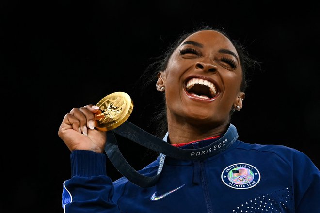 Ameriška gimnastična superzvezdnica Simone Biles je števec zlatih olimpijskih medalj pomaknila na sedem in že razmišlja o še enih olimpijskih igrah. FOTO: Paul Ellis/AFP
