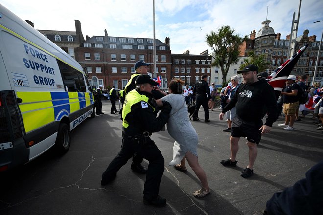 Protestnica med prerivanjem s policisti v Weymouthu na jugozahodu Anglije. FOTO: Justin Tallis/Afp