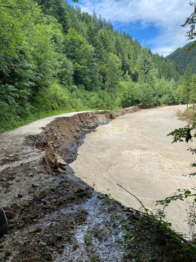 Fotografija zgoraj kaže danes urejen odsek, tako pa je bilo ob lanski ujmi, ko je voda odnesla lokalno cesto in za več kot pol leta onemogočila dostop do domov prebivalcem. FOTO: Gregor Križnik