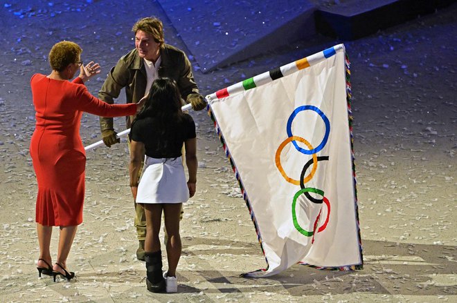 Tom Cruise je olimpijsko zastavo virtualno odnesel iz Pariza v Los Angeles. FOTO: Miguel Medina/AFP