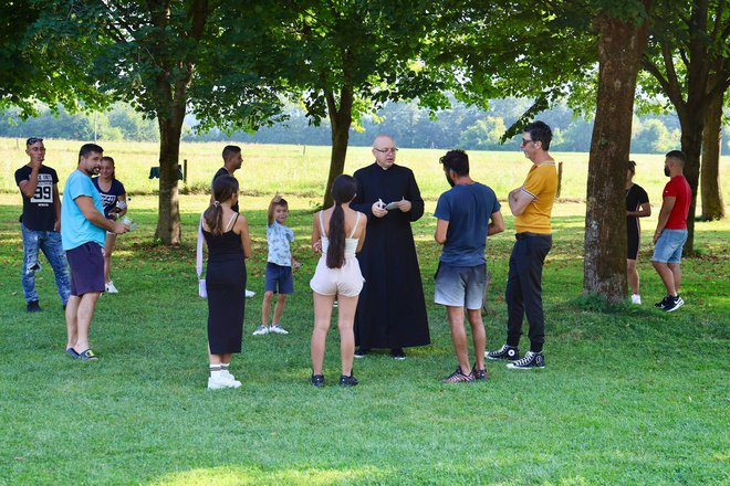 Duhovnik Peter Kokotec je v senci obiskal romsko družino z Dolenjske. FOTO: Voranc Vogel/Delo