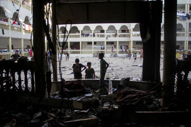 V izraelskem napadu na šolo, kamor so se zatekli razseljeni palestinski civilisti, je bilo v soboto ubitih približno sto ljudi. FOTO: Mahmoud Issa/Reuters