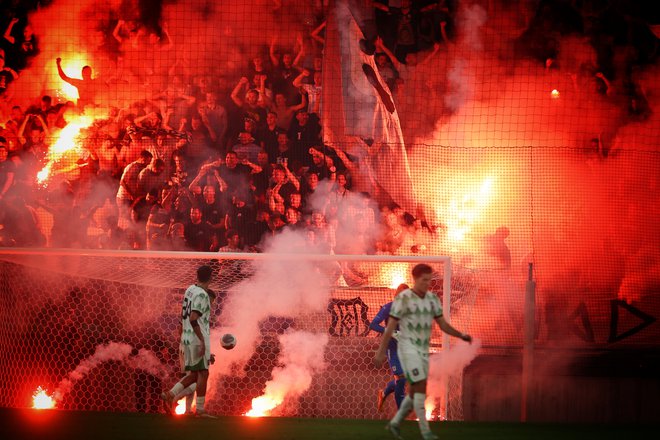 Gostujoči navijači so zakuhali škandal z metanjem bakel in drugih pirotehničnih sredstev, zaradi česar so sodniki prekinili tekmo. FOTO: Jože Suhadolnik/Delo