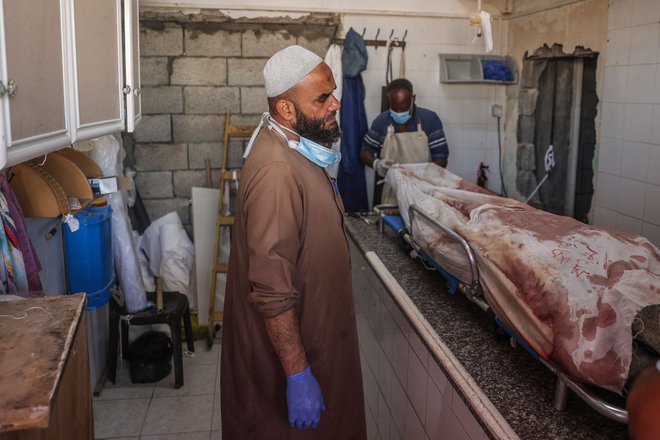 Palestinec v mrtvašnici, kamor so po izraelskem napadu pripeljali trupla ubitih. FOTO: Eyad Baba/Afp