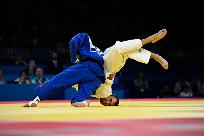 Francoz Frances Nathan Petit in Uzbekistanec Uchkun Kuranbajev tekmujeta v četrtfinalni borbi J2 v kategoriji do 73 kg na paraolimpijskih igrah v areni Champ-de-Mars v Parizu. Foto: Julien De Rosa/Afp