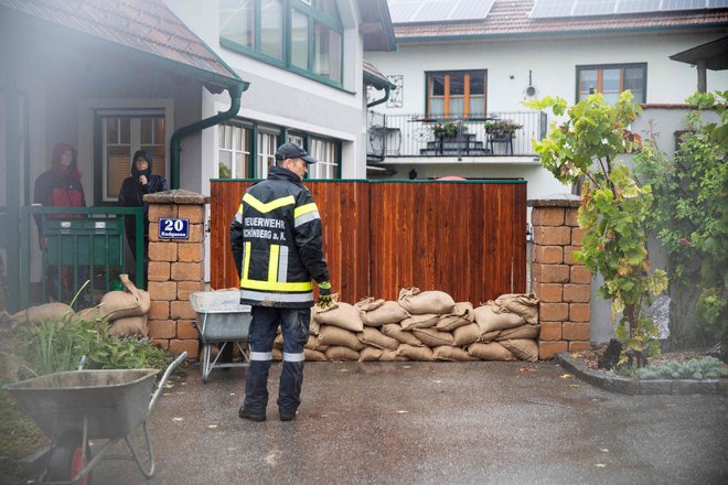 Gasilci in prebivalci kraja Schoenberg am Kamp, kjer so napovedane obsežne poplave, nameščajo protipoplavne vreče. FOTO: Alex Halada/Afp