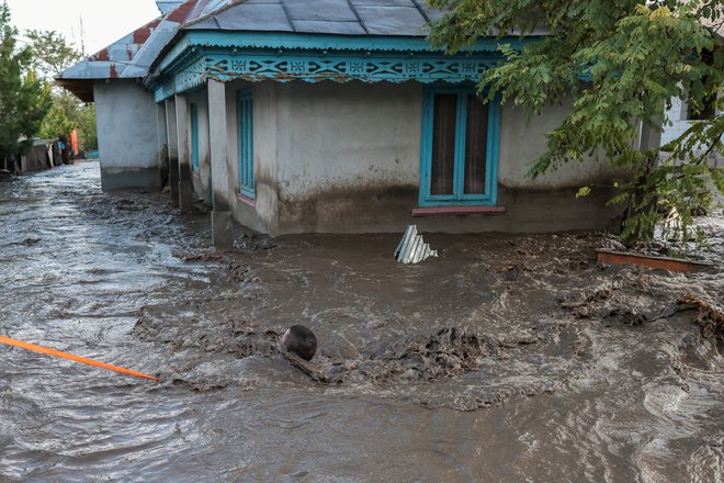 Reševanja moškega iz narasle vode v vasi Slobozia Conachi v romunski regiji Galati. FOTO: George Calin via Reuters