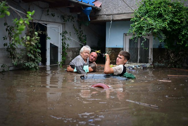 Včerajšnje reševanje starejše osebe v romunski vasi Slobozia Conachi. FOTO: Daniel Mihailescu/AFP