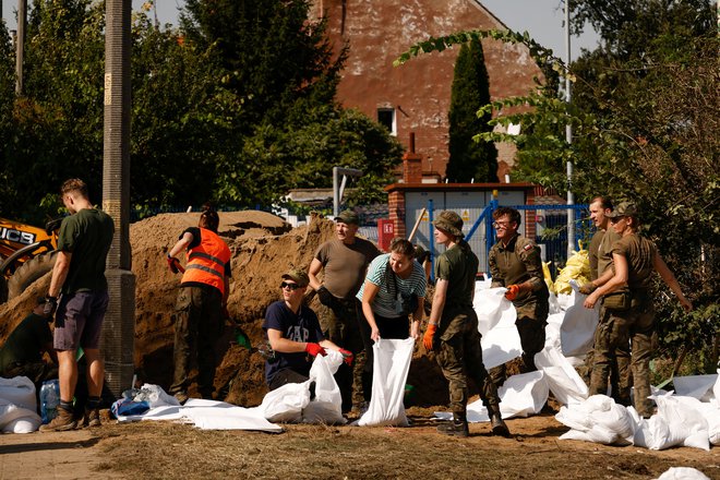 Vojaki in civilisti v Vroclavu med polnjenjem vrečk s peskom. FOTO: Kuba Stezycki/Reuters