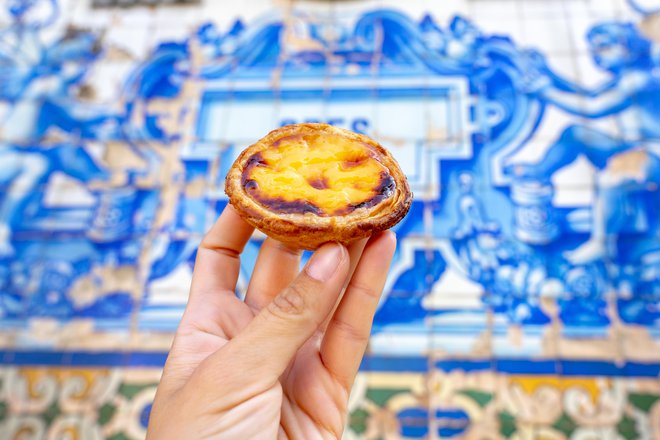 Dva elementa, ki poosebljata Portugalsko: belo-modre ploščice in pastel de nata, ki je ena od stvari, ki jih je treba okusiti. FOTO: Shutterstock