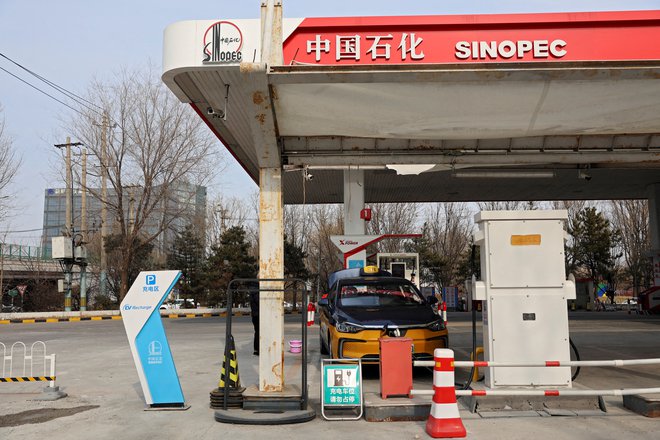 Klasično točenje goriva na Kitajskem vse bolj zamenjuje polnjenje električnih vozil. Na fotografiji je črpalka v Pekingu.

FOTO: Florence Lo/Reuters