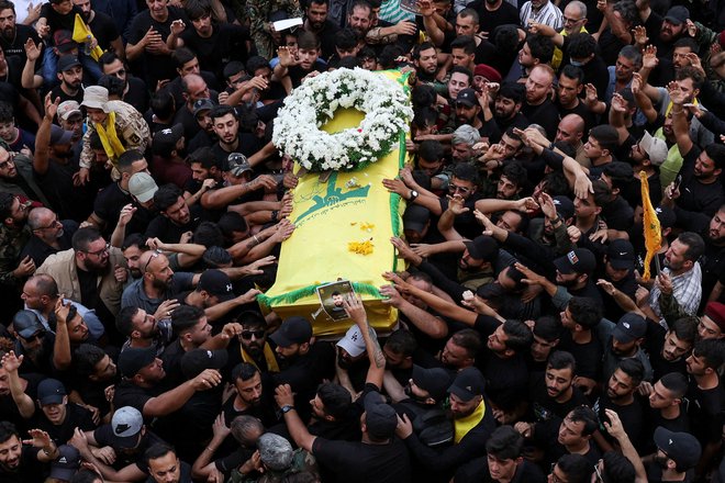 Žalujoči na pogrebu članov Hezbolaha po eksploziji ročnih radijskih sprejemnikov in pozivnikov, ki jih uporablja oborožena skupina Hezbolah. FOTO: Emilie Madi/Reuters