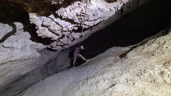 Na dnu jame je močan vodni tok, ki se na koncu izliva v veliko podzemno jezero, rov, po katerem priteče voda, pa še čaka na nadaljnje raziskave.  FOTO: Društvo za raziskovanje jam Ljubljana