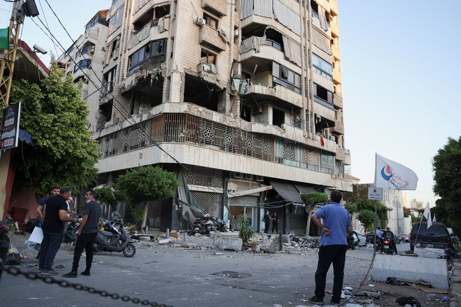 Moški si ogleduje poškodovano stavbo v četrti Bachoura v Bejrutu, ki jo je zadela izraelska vojska. FOTO: Emilie Madi/Reuters