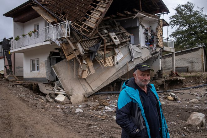 Šerif Hakalović se sprehaja mimo uničene hiše po poplavah in plazovih v Bosni in Hercegovini. FOTO: Marko Djurica/Reuters