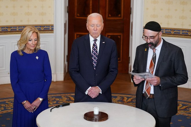 U.S. President Joe Biden, flanked by first lady Jill Biden and Rabbi Aaron Alexander of Adas Israel Congregation, participate in a candle lighting event to mark the anniversary of the Oct. 7 Hamas attacks on Israel, at the White House in Washington, U.S., October 7, 2024. REUTERS/Nathan Howard