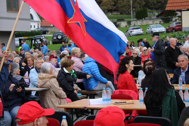 Nad množico obiskovalcev je vihrala nekdanja slovenska zastava s peterokrako zvezdo v sredini. FOTO: Bojan Rajšek/Delo