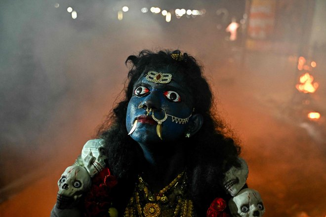 Hindujski vernik, oblečen v boginjo Kali, nastopa med praznovanjem festivala »Kulasai Dasara« v Kulasekharapatnamu v indijski zvezni državi Tamil Nadu. Foto: Idrees Mohammed/Afp