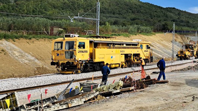 Polaganje prvih tirnic s posebno železniško mehanizacijo (podbijalko), ki zagotavlja višinsko in smerno uravnavo tira. Foto 2TDK