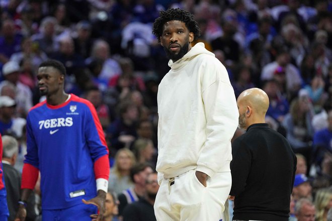 Joel Embiid ob strani igrišča med uvodno tekmo sezone. FOTO: Mitchell Leff/AFP