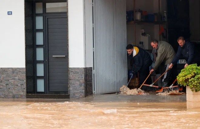 Ljudje v obupu poskušajo rešiti svoje domove. FOTO: Eva Manez/Reuters