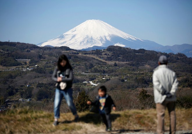 Novica o snegu, ki je pobelil vrh japonske svete gore, je razveselila številne Japonce. FOTO: Issei Kato/Reuters