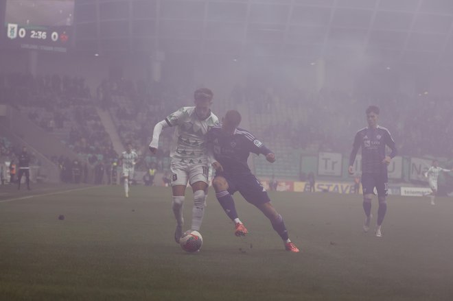 Nogometaši Olimpije in Maribora so se »izgubili« v megli. FOTO: Leon Vidic/Delo