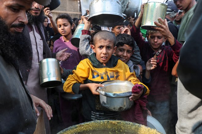 Sestradani Palestinci v vrstah čakajo na humanitarno pomoč. FOTO: Ramadan Abed/Reuters