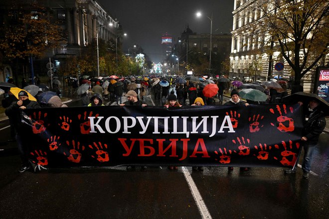 Protestniki s transparentom 'korupcija ubija' na ponedeljkovih protestih. FOTO: Andrej Isakovic/AFP