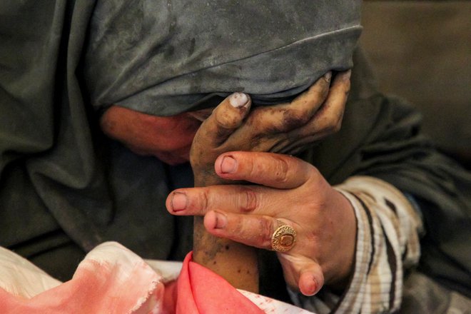 Junij 2024. Palestinka Buthayna Abu Jazar drži za roko svojega sina Hazmo, ki je bil ubit v izraelskem napadu v Rafi na jugu Gaze. Foto: Hatem Khaled/Reuters