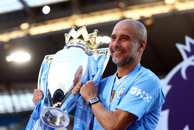 Pep Guardiola s pokalom za naslov angleškega prvaka. FOTO: Lee Smith/Reuters