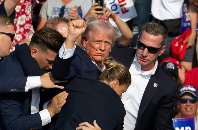 Julij 2024. Bivši predsednik ZDA Donald Trump je preživel poskus atentata, potem ko so na njegovem političnem zborovanju v mestu Butler v Pensilvaniji odjeknili streli. V incidentu je bil ubit eden od udeležencev zborovanja, dva sta v kritičnem stanju. Napadalec je bil 20-letni Thomas Matthewa Crooks. Foto: Rebecca Droke/Afp