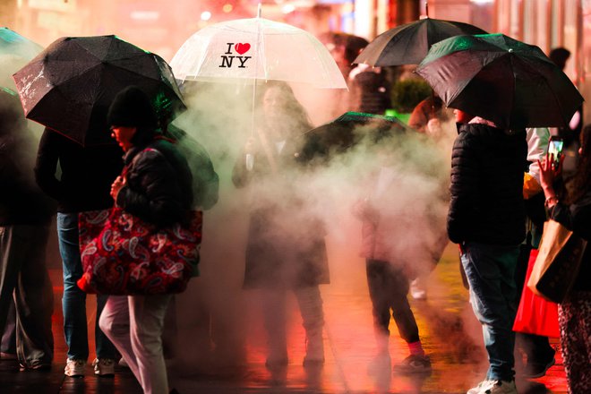 TOPSHOT - People hold umbrellas as they walk under the rain in a street of the Manhattan borough of New York City on November 22, 2024. (Photo by CHARLY TRIBALLEAU/AFP) Foto Charly Triballeau Afp